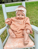Little girl is wearing a comfortable baby headband for little girls from By Bella Boutique.